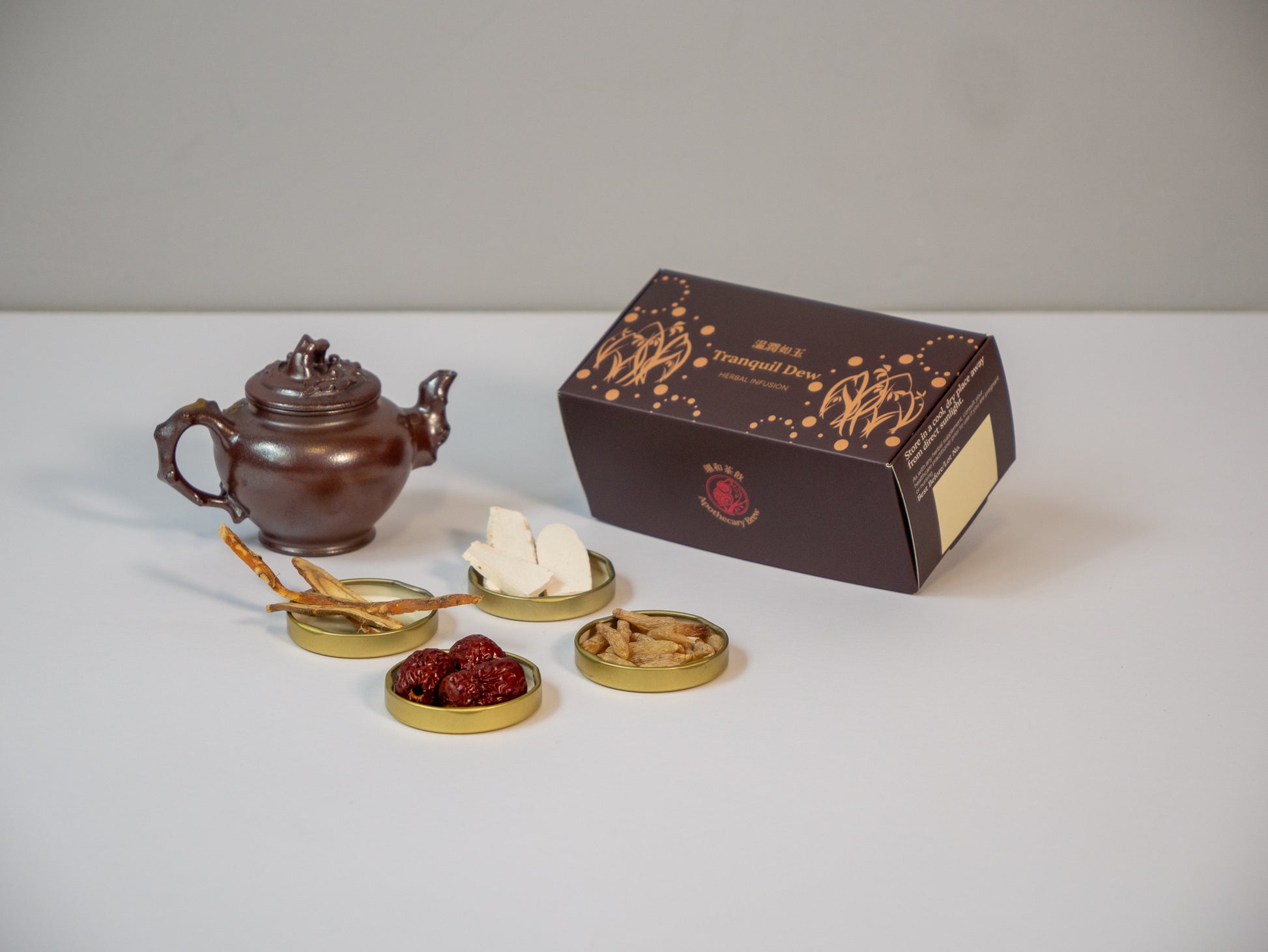 Tranquil Dew herbal wellness tea box surrounded by raw TCM ingredients: Huai Shan, Mai Men Dong, Licorice Root, and Red Dates for soothing stomach discomfort and lung immunity.
